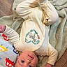 Atlas joined the competition — help win amazing prizes! baby, infant, onesie, blanket, floor, wooden_floor, face, child, cute, playful, lying_down, soft_texture, clothing, zebra_design, indoor, person, head, expression, footwear, home