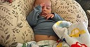 Atlas joined the competition — help win amazing prizes! baby, sleeping, blanket, pillow, couch, knitted_throw, diaper, clothing, hand, face, infant, cozy, indoor, resting, peaceful, soft_texture, patterned, colorful, comfort, child