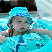 Greyson joined the competition — help win amazing prizes! aqua, baby, child, closeup, cute, expression, face, float, fun, headwear, infant, inflatable_pool, outdoor, playtime, skin, summer, sunlight, swim_hat, water, water_droplets