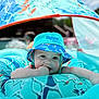 Greyson is registered to the contest to win money with this photo: aqua, baby, blue, child, cute, face, hand, inflatable_float, outdoor, pattern, pool, relaxing, sucking_fingers, summer, sunlight, swim_hat, swim_school, turquoise, water, young_child