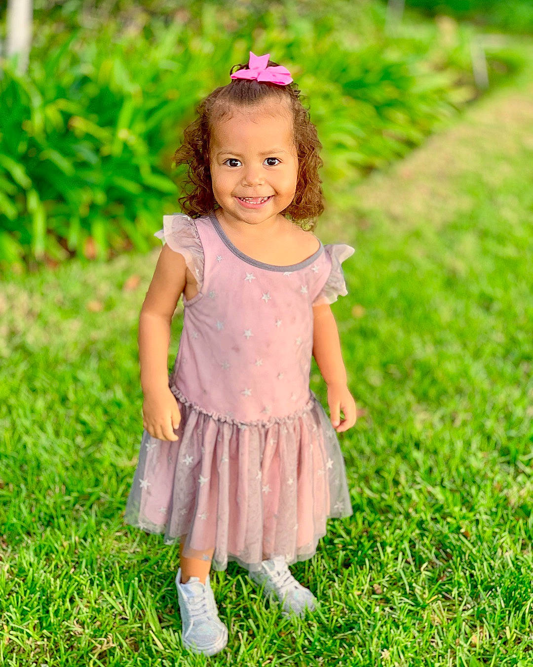 Symphony is registered to the contest to win money with this photo: child, child_model, dance_dress, dress, girl, grass, hair_accessory, happiness, infant, joy, meadow, person, pink, smile, toddler