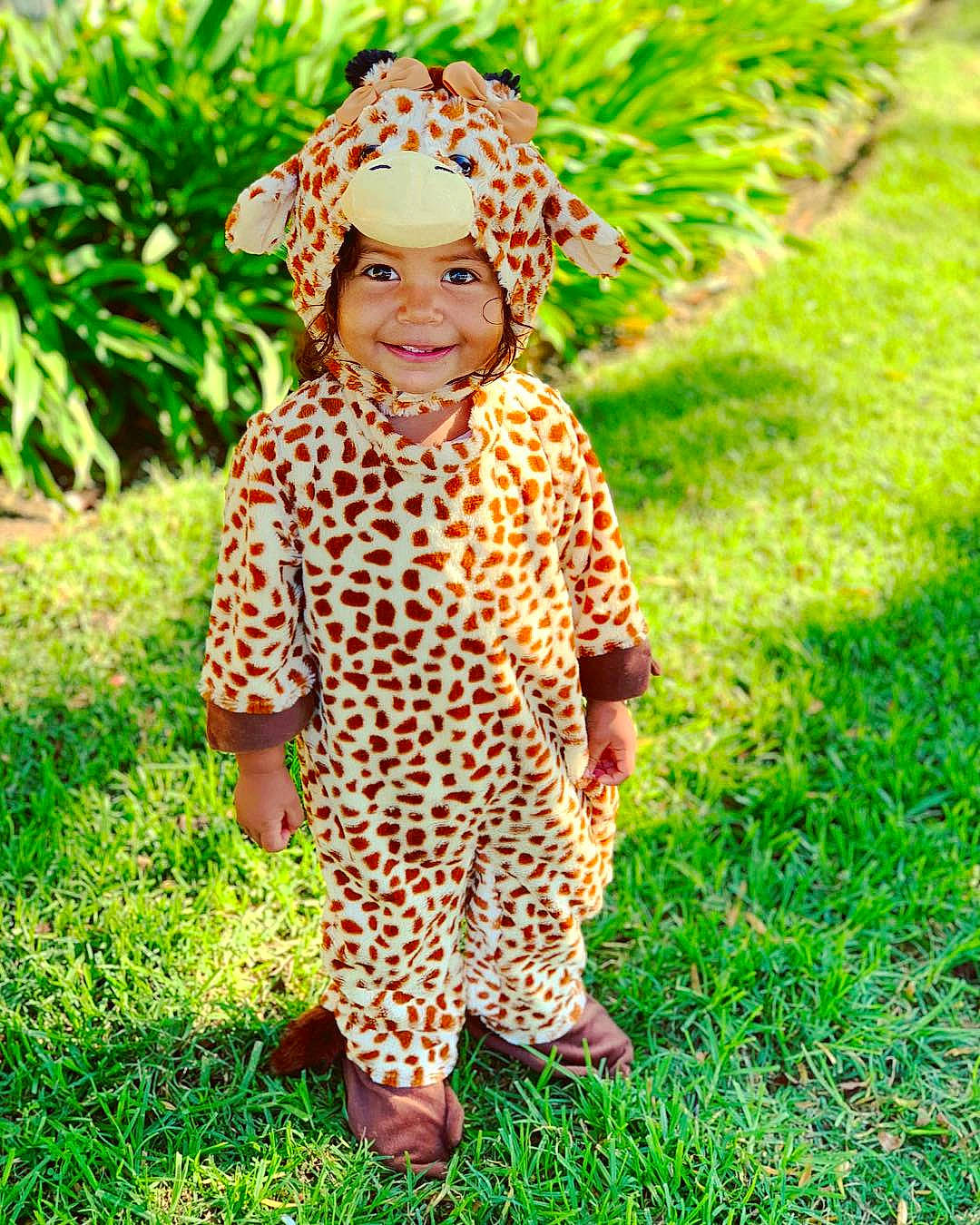 Symphony is registered to the contest to win money with this photo: child, clothing, flower, giraffe, giraffidae, girl, grass, grass_family, headgear, headwear, joy, leaf, mammal, pattern, person, plant, smile, toddler, tree