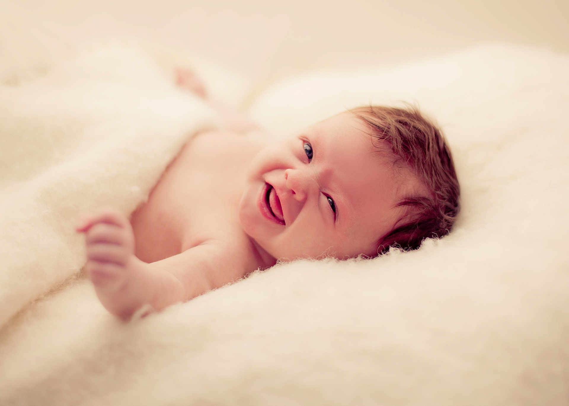 Lilith is registered to the contest to win money with this photo: baby, smiling, blanket, soft, happy, infant, cute, portrait, skin, newborn, hand, face, child, cozy, warm, lying_down, expression, closeup, natural_light, comfort