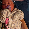 Faith is registered to the contest to win money with this photo: baby, sleeping, pacifier, onesie, floral_pattern, doodle, cat_ears, whiskers, hand, blanket, bed, cute, infant, child, peaceful, pink_beads, toy, clothing, portrait, indoors