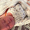 Faith is registered to the contest to win money with this photo: newborn, baby, sleeping, blanket, pajamas, patterned_clothing, soft_texture, cozy, infant, peaceful, wrapped, closeup, face, head, resting, indoor, cute, child, portrait, warm