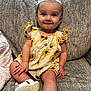 baby, bow, child, couch, cushion, cute, earrings, face, hands, happy, indoor, infant, legs, portrait, romper, sandal, sitting, smile, sofa, sunflower_print