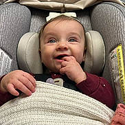 Savannah is registered to the contest to win money with this photo: baby, infant, car_seat, blanket, bow, smiling, happy, child, face, hand, cozy, knit, comfort, seatbelt, indoors, cute, portrait, head_support, clothing, pacifier
