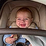 baby, smiling, infant, car_seat, safety_harness, blue_clothing, blanket, cute, child, indoor, happy, closeup, person, seatbelt, soft_texture, young_child, portrait, baby_hand, human_face, cozy