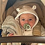 baby, pacifier, blanket, stroller, hoodie, knitted_clothing, child, infant, cute, face, hand, comfort, soft, seated, warm_clothing, baby_accessory, car_seat, portrait, childcare, young