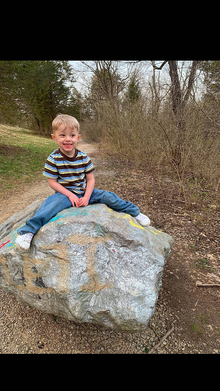 Clayton is registered to the contest to win money with this photo: boulder, child, geology, joy, person, photography, play, rock, sitting, soil, toddler, tree