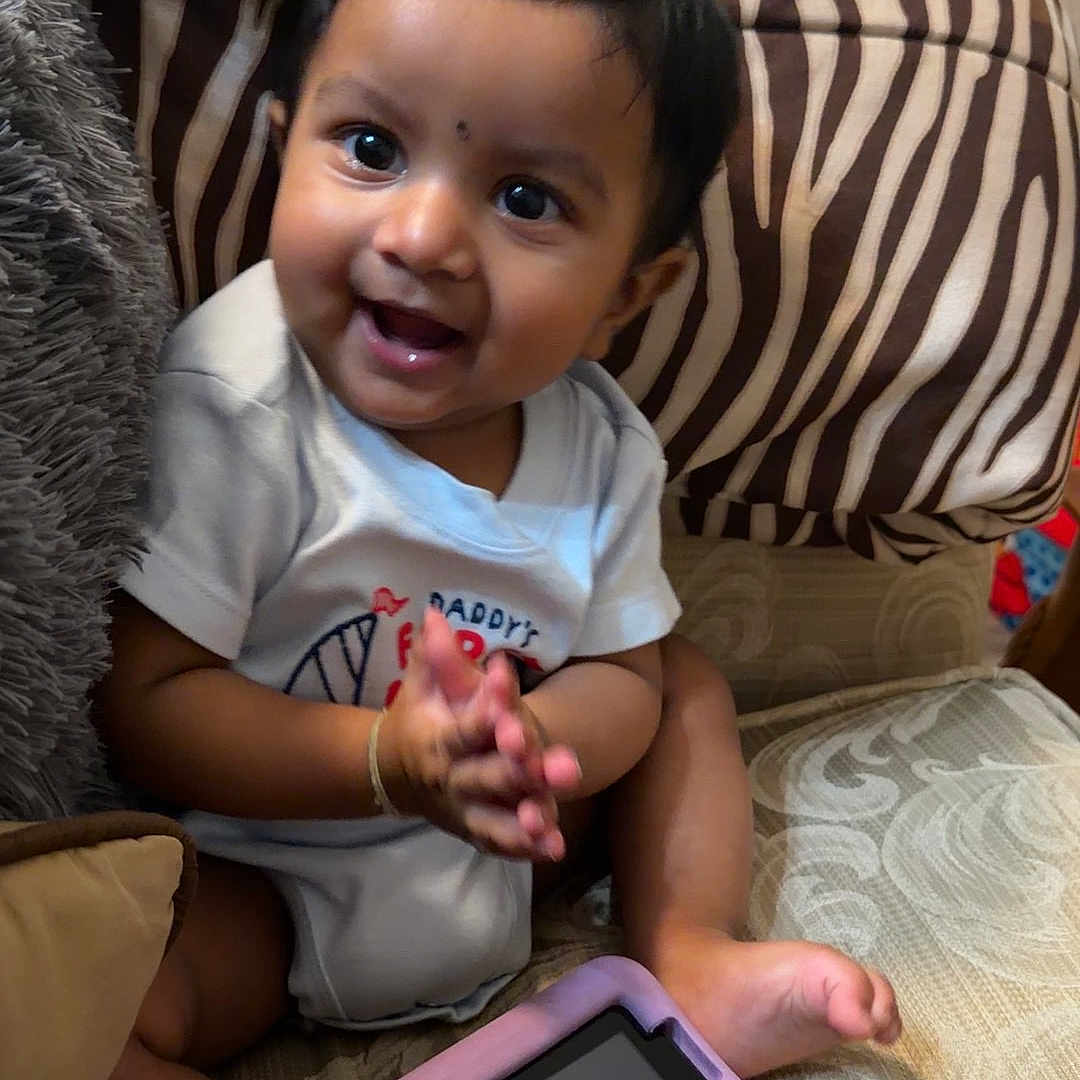 Deaaron joined the competition — help win amazing prizes! baby, child, infant, sitting, smiling, happy, portrait, face, eyes, hands, couch, cushion, tablet, indoors, home, furniture, patterned_fabric, short_hair, casual_clothing, playtime