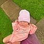 baby, infant, pink_hat, pink_onesie, sleeping, outdoor, grass, pathway, person_holding, peaceful, cute, child, knit_hat, soft_lighting, closeup, newborn, toddler, nature, hands, resting