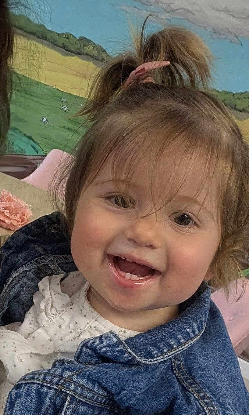 Soa participe au concours pour gagner de l'argent avec cette photo : toddler, child, smiling, face, denim_jacket, white_clothing, hair_tied, indoors, mural, painting, fields, clouds, happy, cute, portrait, baby, person, young_child, casual_wear, cheerful