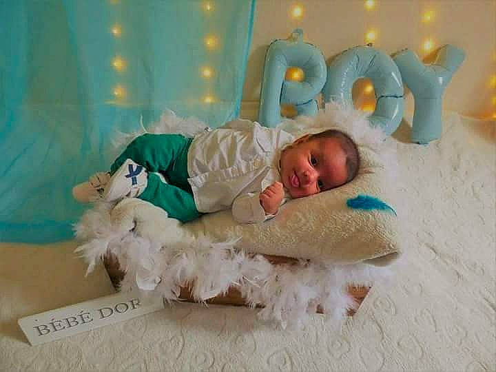 Maël participe au concours pour gagner de l'argent avec cette photo : baby, baby_products, baby_safety, baby_sleeping, baby_toddler_clothing, bedding, child, comfort, event, fashion_accessory, fun, hair_accessory, happy, headband, headpiece, linens, person, room, sitting, sock