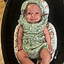 baby, infant, smile, green_outfit, headband, baby_seat, rainbow_pattern, cute, happy, child, indoor, portrait, clothing, legs, arms, face, person, seat, comfort, expression