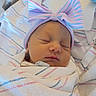 Juniper is registered to the contest to win money with this photo: newborn, baby, sleeping, infant, portrait, face, bow, hat, swaddled, blanket, hospital_blanket, pastel, pink, blue, bed, indoors, peaceful, cozy, close_up, photography