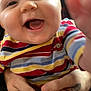Richtofen is registered to the contest to win money with this photo: baby, smiling, child, striped_clothing, hand, tattoo, person, closeup, happy, infant, face, cute, touching, joy, human, skin, expression, holding, colorful, portrait
