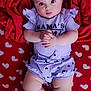 ïnayâ participe au concours pour gagner de l'argent avec cette photo : baby, infant, red_blanket, heart_pattern, purple_outfit, ruffles, bow, face, hands, legs, feet, cute, lying_down, indoors, soft_texture, child, adorable, portrait, expression, clothing
