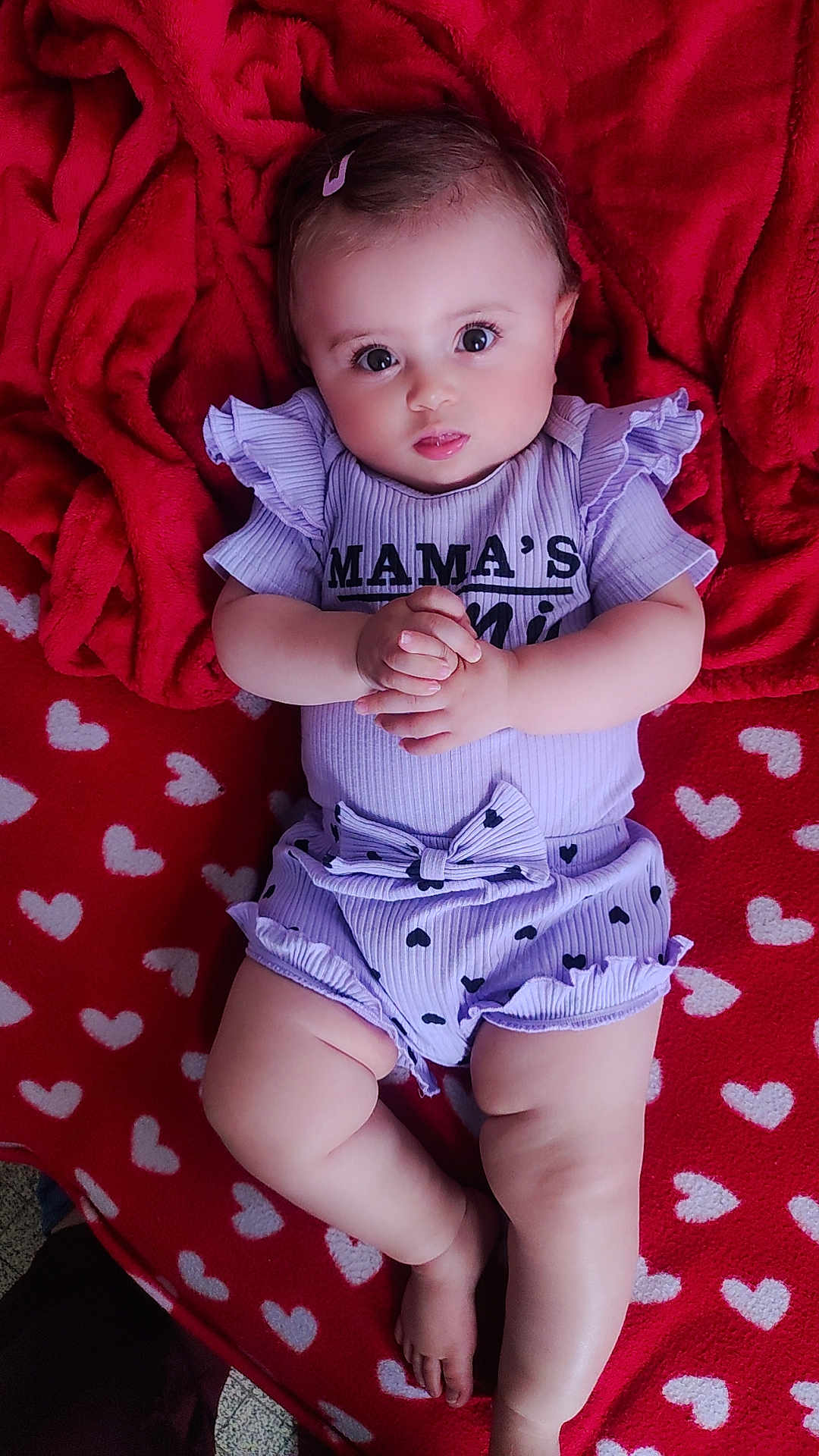 ïnayâ participe au concours pour gagner de l'argent avec cette photo : baby, infant, red_blanket, heart_pattern, purple_outfit, ruffles, bow, face, hands, legs, feet, cute, lying_down, indoors, soft_texture, child, adorable, portrait, expression, clothing