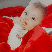 ïnayâ a rejoint le concours — aidez-le/la à gagner de superbes lots ! baby, child, blanket, red_blanket, hand, face, eyes, infant, cute, cozy, indoor, person, sitting, soft_texture, warm, clothing, cute_expression, portrait, young_child, comfort
