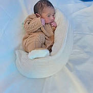 Zayan joined the competition — help win amazing prizes! baby, infant, knitted_clothing, blanket, white_blanket, newborn, sleeping, cozy, soft, cute, small, wrapped, indoors, bed, resting, child, person, portrait, warm, peaceful