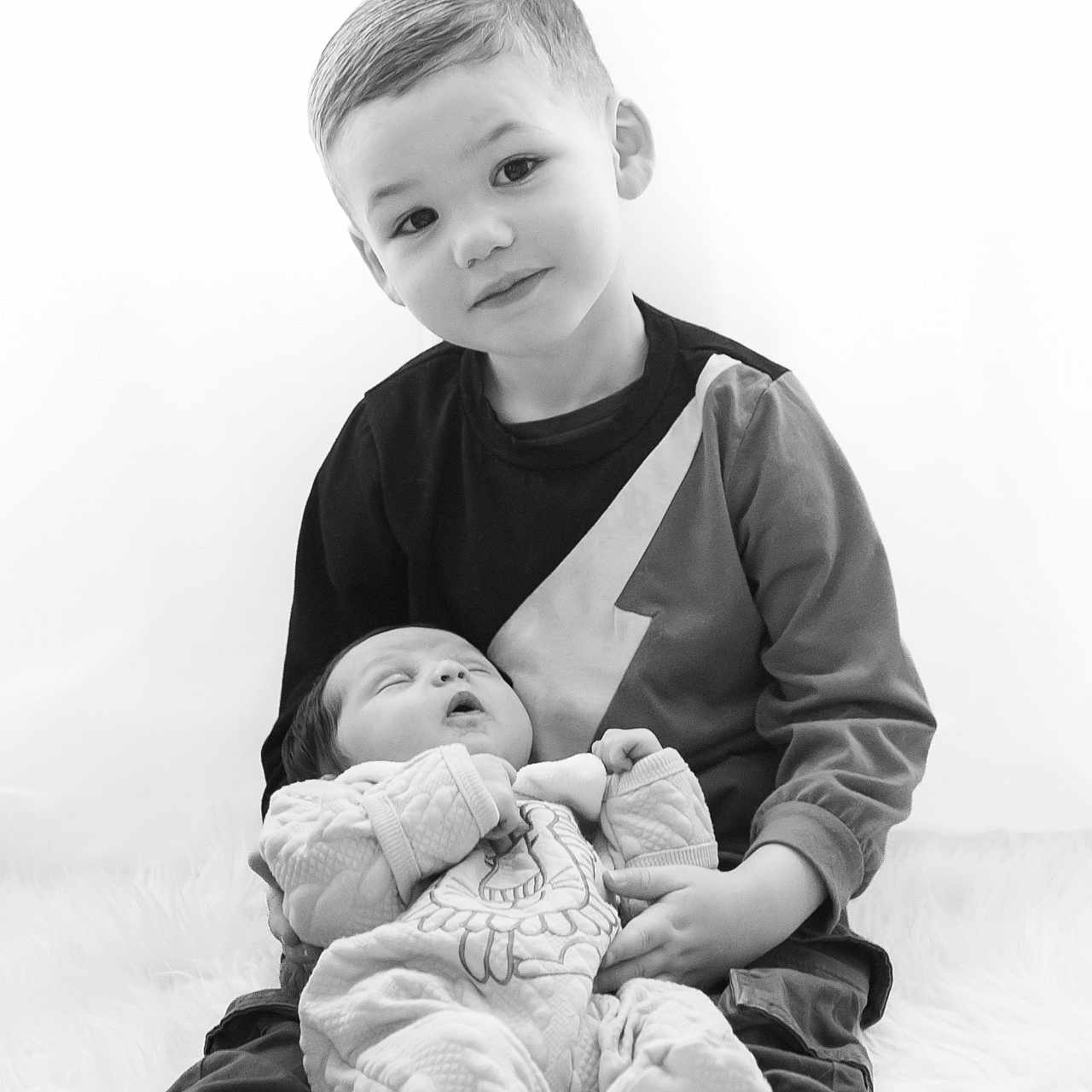 Manoah participe au concours pour gagner de l'argent avec cette photo : baby, black_and_white, child, clothing, cuddling, cute, family, happy, indoors, infant, love, monochrome, portrait, sibling, sleeping, smile, soft_texture, toddler, together, young