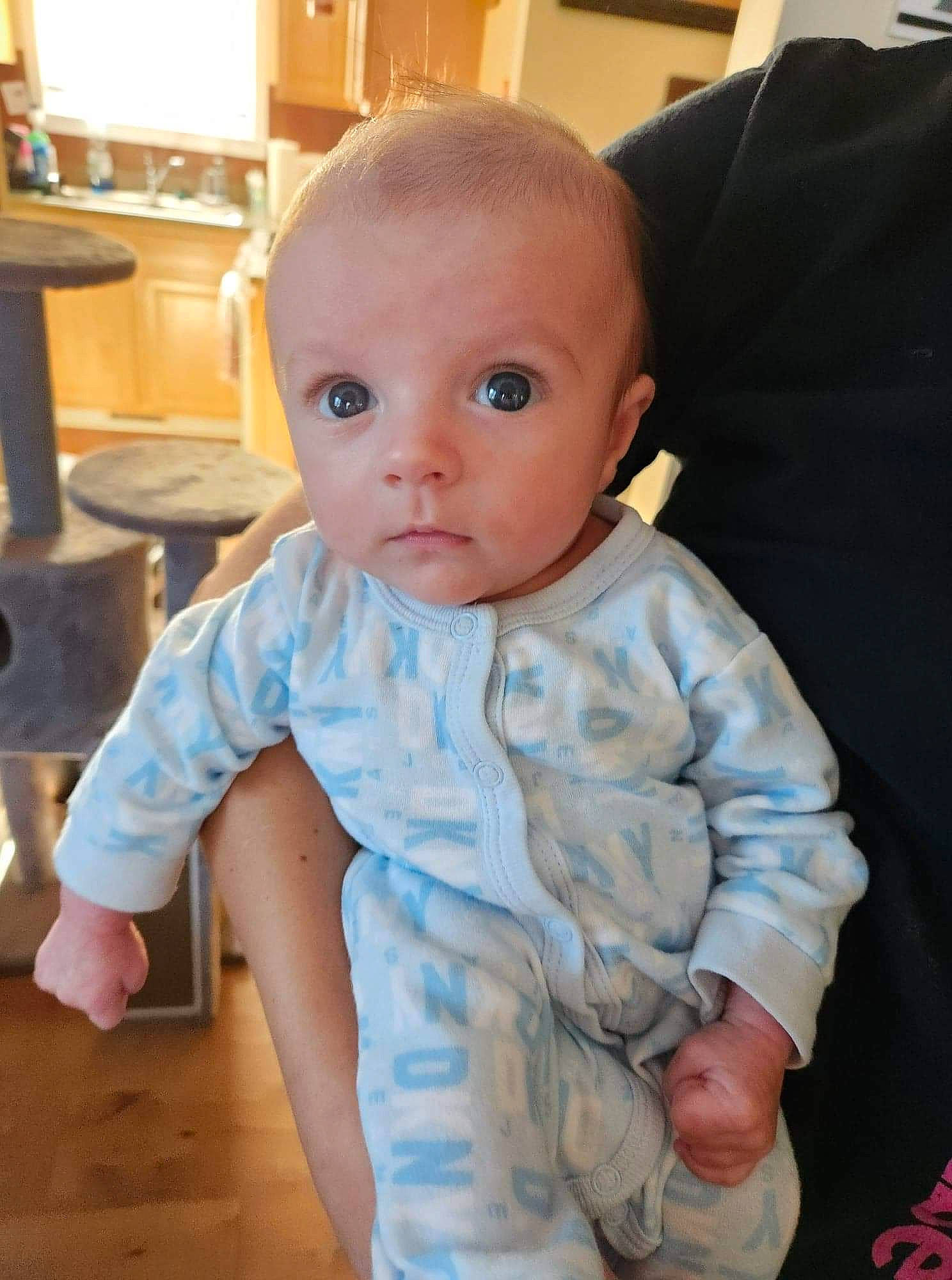 Benjamin is registered to the contest to win money with this photo: baby, baby_toddler_clothing, cheek, child, chin, comfort, electric_blue, eye, floor, flooring, hardwood, iris, nose, pattern, person, sitting, skin, sleeve, thumb, toddler