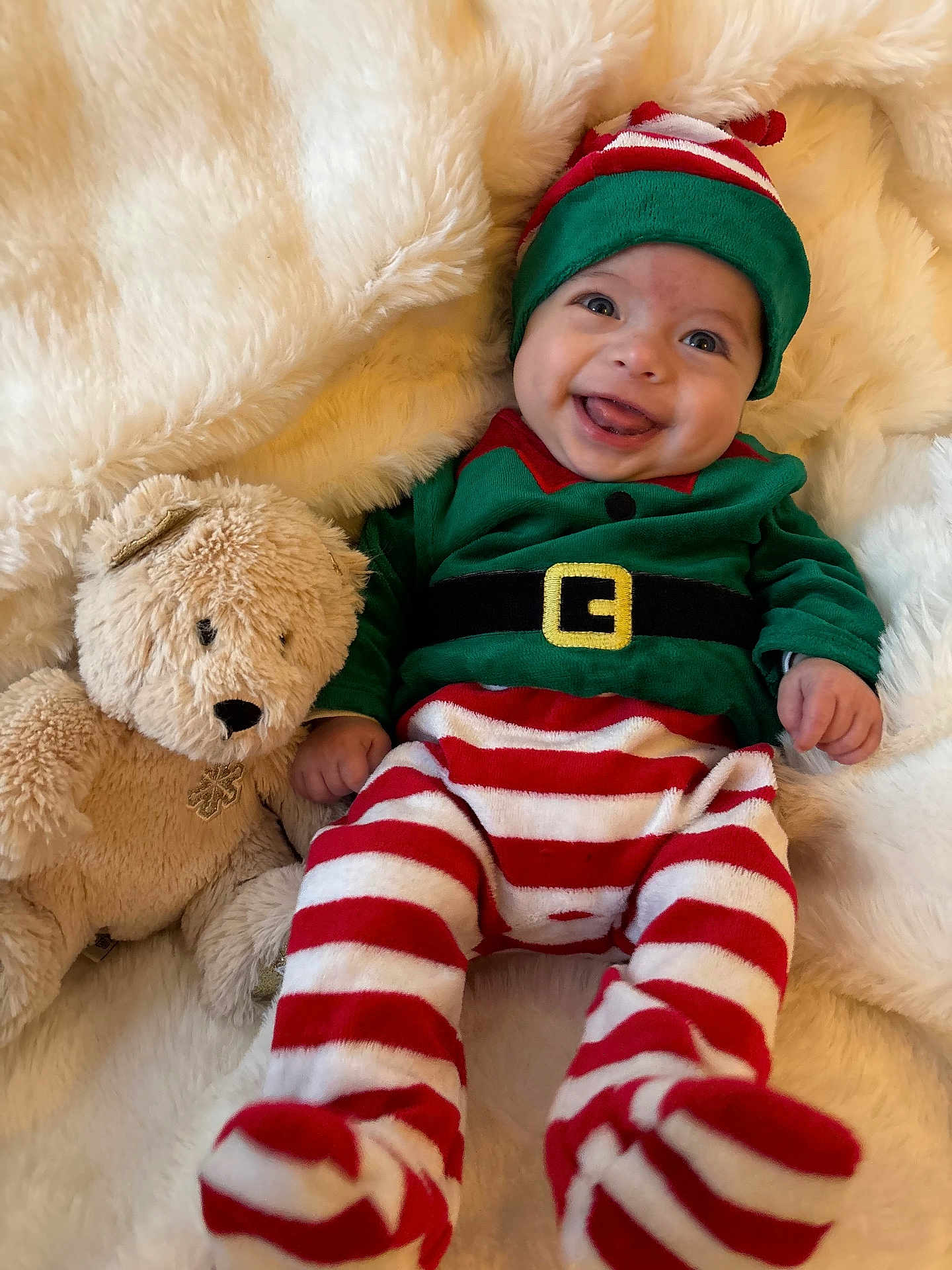 Fabio a rejoint le concours — aidez-le/la à gagner de superbes lots ! baby, infant, smiling, elf_costume, striped_pants, green_top, teddy_bear, soft_toy, blanket, fluffy, cute, happy, holiday, festive, child, portrait, indoors, cozy, playful, lying_down