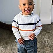 Kaïs a rejoint le concours — aidez-le/la à gagner de superbes lots ! child, toddler, smiling, standing, indoor, sweater, striped_clothing, cargo_pants, white_sneakers, flooring, wood_floor, happy, cute, person, clothing, portrait, young_child, casual_wear, feet, hands