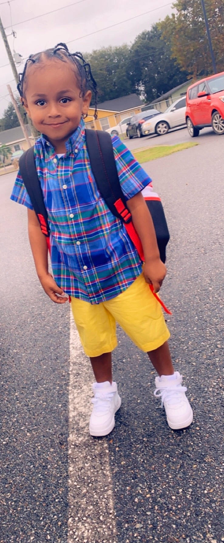 Malcolm is registered to the contest to win money with this photo: asphalt, car, cool, footwear, hairstyle, joy, orange, outerwear, person, photograph, plaid, shoe, shorts, sleeve, smile, sneakers, t_shirt, tartan, tire, wheel