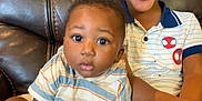 Kaji is registered to the contest to win money with this photo: child, baby, smiling, happy, sitting, couch, leather, striped_shirt, patterned_shirt, hands, face, eyes, short_hair, indoor, brothers, cute, joyful, portrait, family, casual_clothing