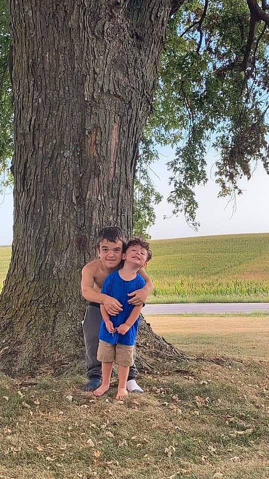 Cameron joined the competition — help win amazing prizes! fun, grass, grassland, happy, landscape, leisure, natural_landscape, nature, people_in_nature, person, plant, recreation, shorts, sitting, sky, soil, spring, toddler, tree, trunk