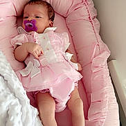 Nevaeh is registered to the contest to win money with this photo: baby, infant, pacifier, pink, blanket, cushion, clothing, cute, newborn, sleepwear, footwear, socks, frills, portrait, resting, indoors, soft, comfort, child, person