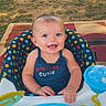 baby, smiling, outdoor, baby_seat, toy, polka_dot, child, happy, infant, clothing, cute, playful, sunny, grass, blanket, seat, portrait, person, blue, face