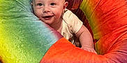 Malachi joined the competition — help win amazing prizes! baby, infant, smile, face, child, colorful, plush, rainbow, soft, cushion, seated, happy, indoors, comfort, cute, bright, young, person, cozy, playful