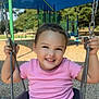 child, toddler, swing, playground, smiling, happy, outdoor, park, play, summer, clothing, person, fun, daylight, seat, metal, greenery, trees, woodchips, casual