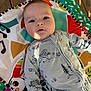 Beau joined the competition — help win amazing prizes! baby, infant, play_mat, onesie, animal_print, tree_print, music_notes, colorful, patterned, wooden_floor, soft_light, cute, child, portrait, indoors, happy, smiling, relaxed, young_child, closeup