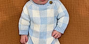Beau joined the competition — help win amazing prizes! baby, infant, knitted_clothing, blue_and_white, hat, pom_pom, booties, blanket, textured_background, cute, portrait, lying_down, young_child, cozy, warm_clothing, looking_at_camera, hand, face, soft_lighting, indoors