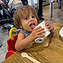Mélody a rejoint le concours — aidez-le/la à gagner de superbes lots ! brown_hair, child, clothing, cup, eating, floor, food, frozen_yogurt, happy, high_chair, indoor, messy_face, people, person, seat, smiling, spoon, stroller, toddler, wooden_table