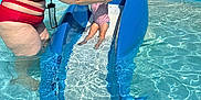Mélody a rejoint le concours — aidez-le/la à gagner de superbes lots ! adult, blue_slide, child, family, fun, net_fence, outdoor, person, play, safety, shallow_water, smiling, splash, summer, sunlight, swimming_pool, swimsuit, water, water_park, water_slide