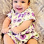 Josslyn is registered to the contest to win money with this photo: baby, smiling, child, purple_flower_dress, cute, happy, infant, soft_blanket, sitting, face, portrait, hand, feet, white_socks, curly_hair, indoors, closeup, adorable, young_child, playful