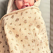 Kleo participe au concours pour gagner de l'argent avec cette photo : adorable, baby, blanket, blue_eyes, child, closeup, curious, cute, expression, face, fingers, hood, indoors, infant, patterned_blanket, portrait, skin, soft_light, wrapped, young