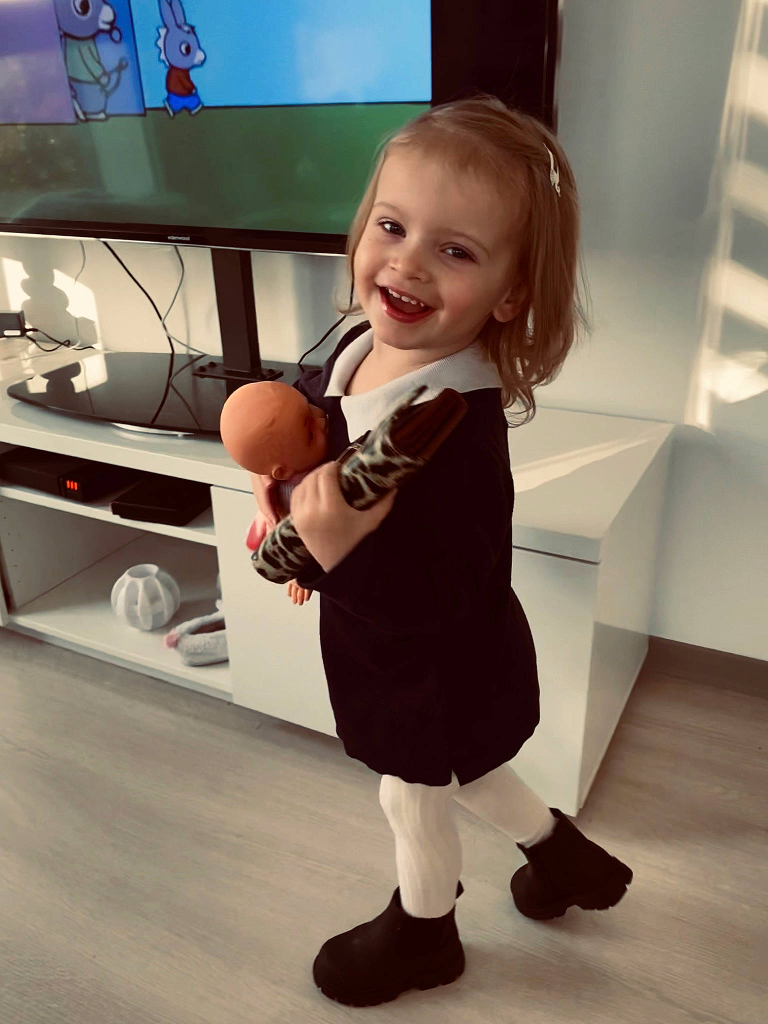 Camilia a rejoint le concours — aidez-le/la à gagner de superbes lots ! baby_toddler_clothing, child, flooring, fun, happy, human_leg, joy, knee, person, sandal, shoe, shoulder, skin, sleeve, smile, sneakers, sock, standing, television, television_set