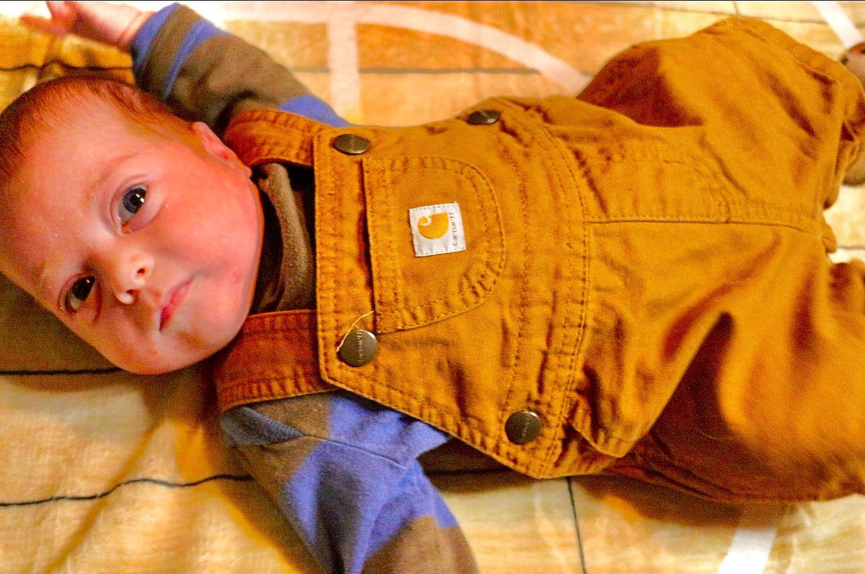 Kaiser is registered to the contest to win money with this photo: baby, baby_products, baby_toddler_clothing, cheek, child, comfort, flooring, fun, headgear, mammal, orange, person, personal_protective_equipment, portrait_photography, room, sitting, sleep, sleeve, toddler, vertebrate