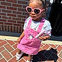 Niema is registered to the contest to win money with this photo: child, girl, pink_dress, heart_sunglasses, braided_hair, phone_case, unicorn, sandals, brick_wall, outdoor, sunlight, shadow, fashion, accessories, cute, summer, sidewalk, portrait, playful, casual