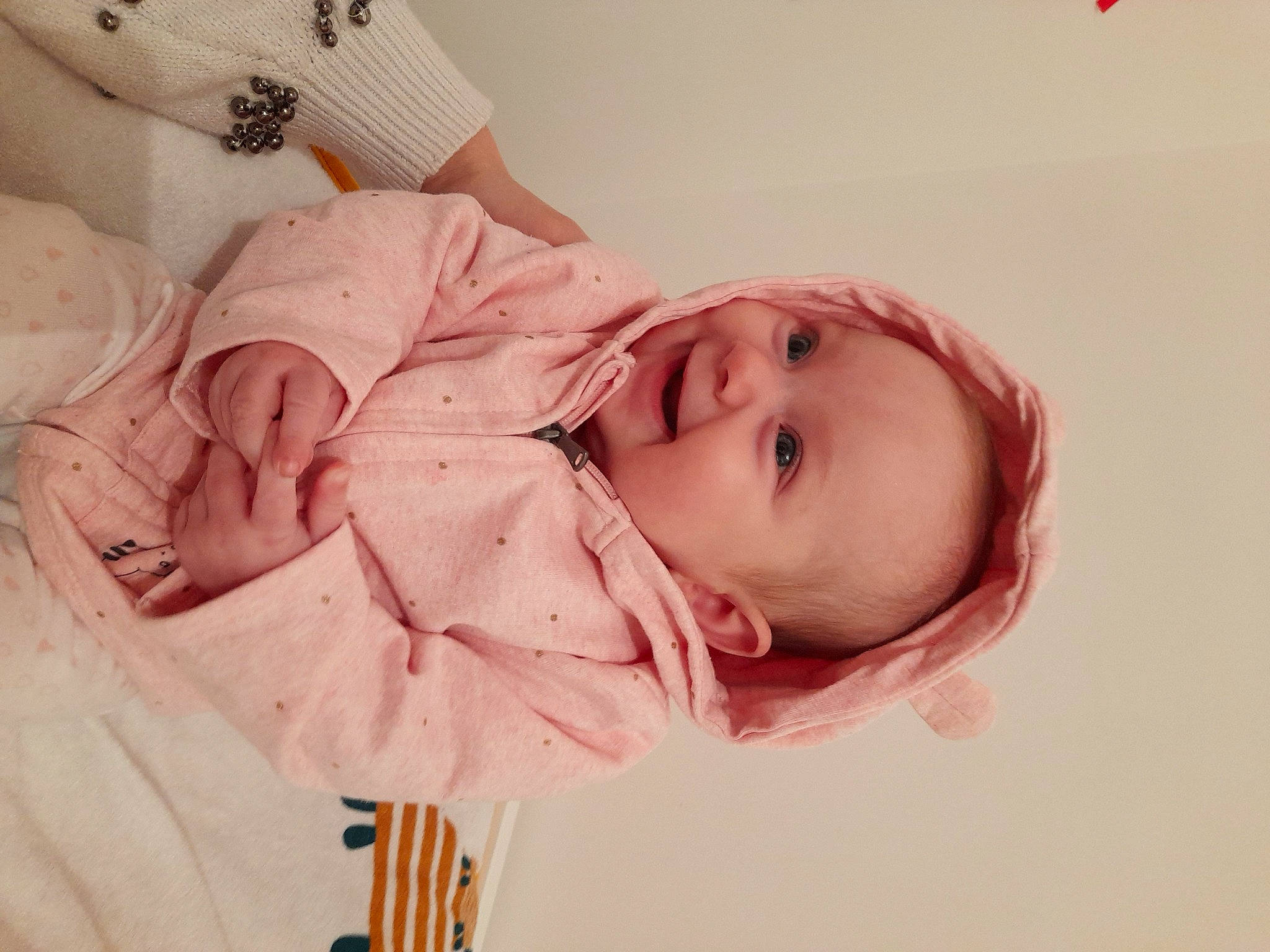 Lyvia participe au concours pour gagner de l'argent avec cette photo : arm, baby, baby_toddler_clothing, cheek, child, comfort, eyelash, flower, hand, happy, headgear, iris, lip, nose, peach, person, pink, skin, sleeve, smile