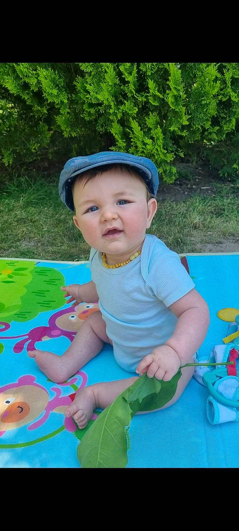 Mathys participe au concours pour gagner de l'argent avec cette photo : baby, baby_toddler_clothing, blue, child, electric_blue, fun, garden, grass, green, happy, headwear, leaf, leisure, people_in_nature, person, plant, play, recreation, shorts, sitting