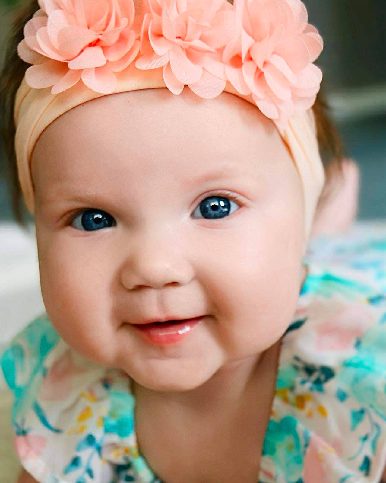 Estella is registered to the contest to win money with this photo: baby, baby_toddler_clothing, cap, eye, eyebrow, eyelash, face, flower, happy, head, headgear, headpiece, headwear, iris, lip, person, petal, pink, plant, skin