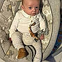 baby, infant, baby_rocker, elephant_print, clothing, pacifier_clip, brown_shoes, wooden_floor, indoor, child, cute, seated, portrait, looking_at_camera, home, furniture, soft_toys, comfort, young_child, curious