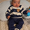 baby, infant, child, portrait, sitting, smiling, bed, pillow, cushion, toy, rattle, striped_clothing, navy_outfit, bear_design, sneakers, indoors, bedroom, cozy, happy, photography